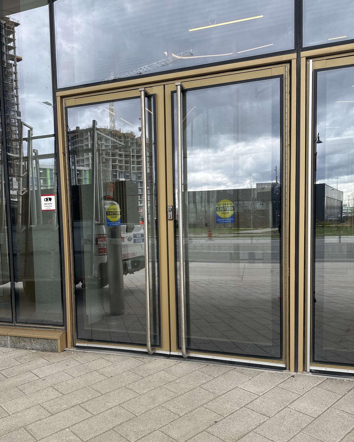 Champagne-anodized narrow-stile aluminum entrance doors in a matching glazed storefront at a new Markham building, installed by Canuck Door Systems