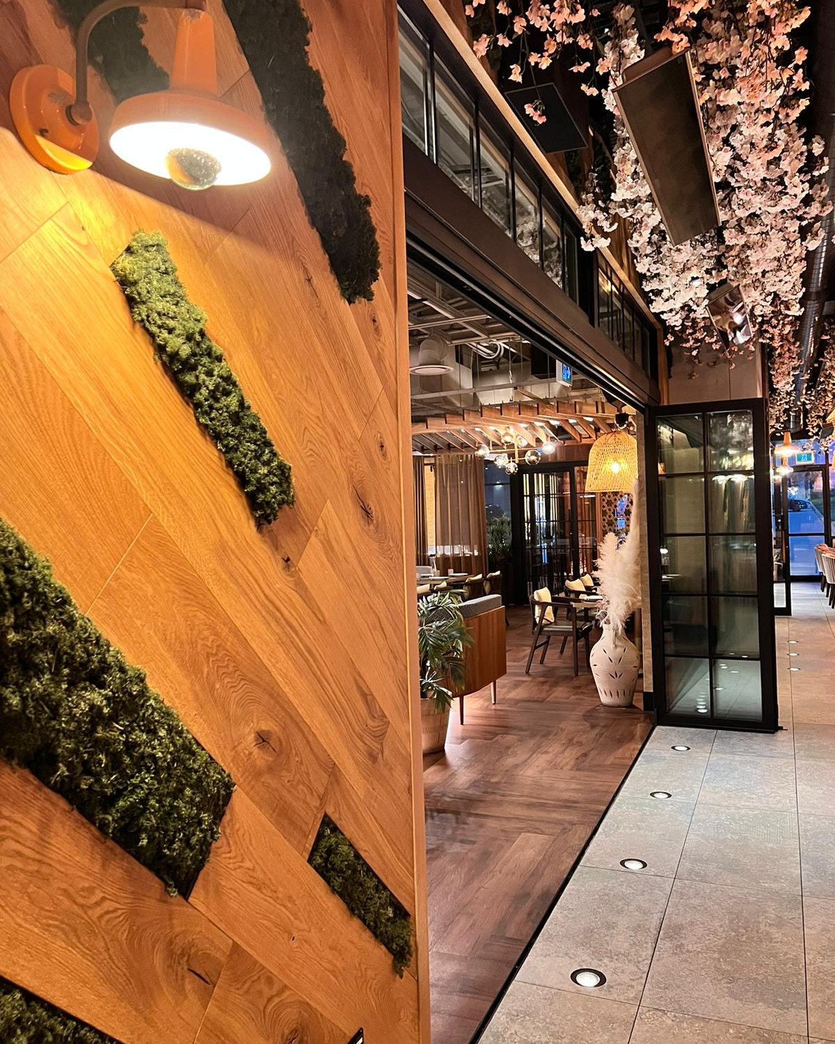 Black-framed bi-folding glass leaves along the side of a restaurant dining room in Mississauga, installed by Canuck Door Systems