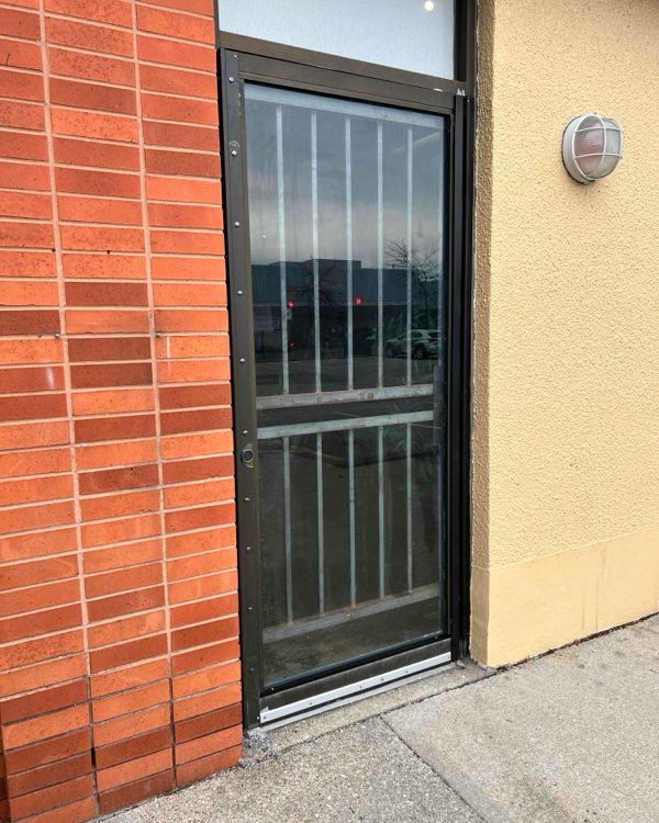 The same commercial entrance door opening reglazed with new glass in its aluminum frame, by Canuck Door Systems