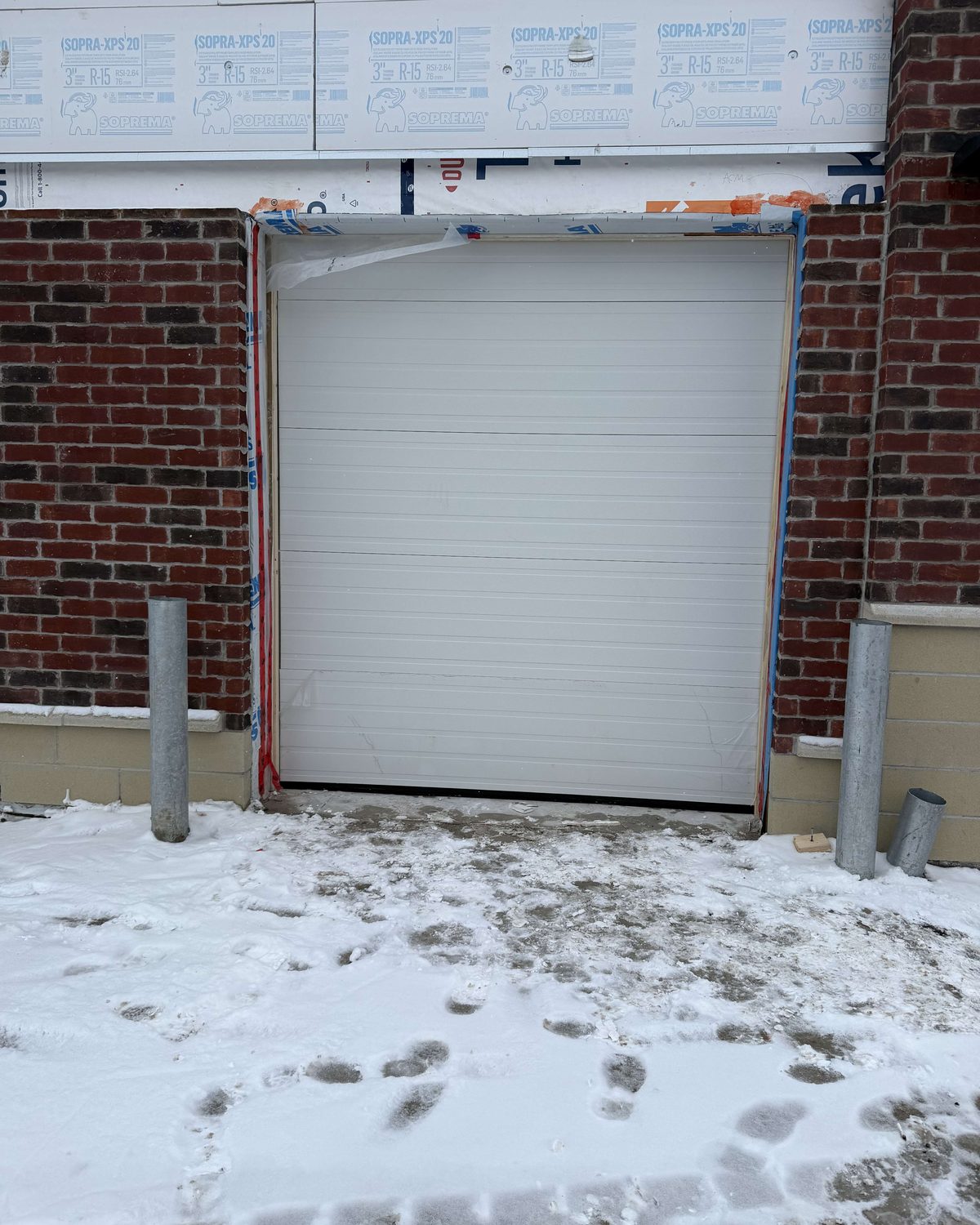 A commercial overhead garage door installed at a service bay opening by Canuck Door Systems