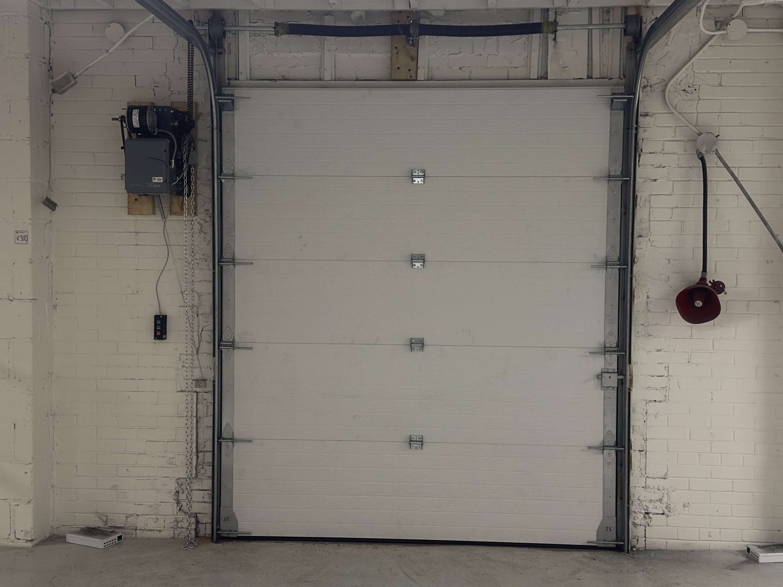 A commercial overhead garage door at a service-bay opening, installed by Canuck Door Systems