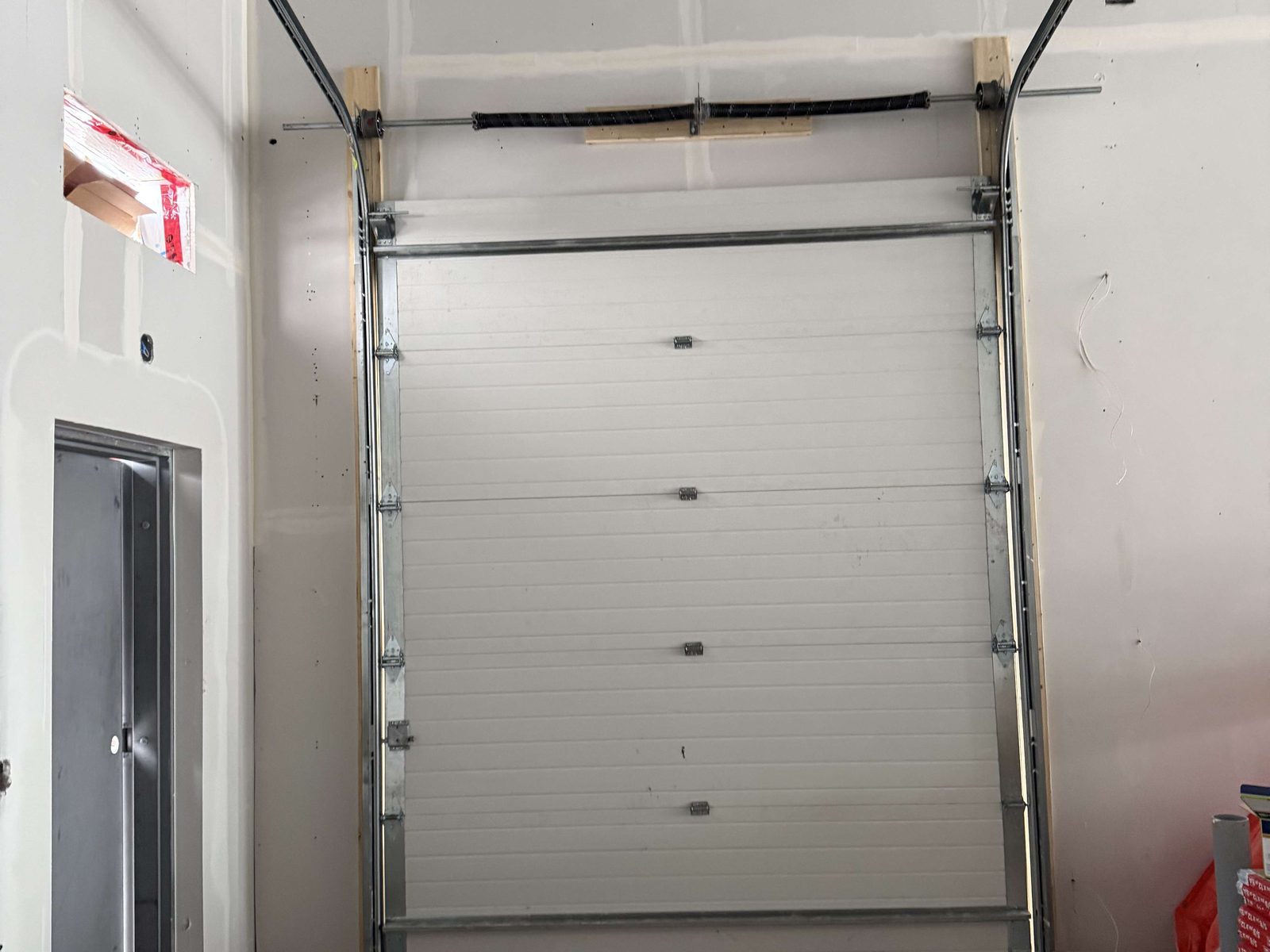 A commercial overhead door at an industrial opening, serviced by Canuck Door Systems