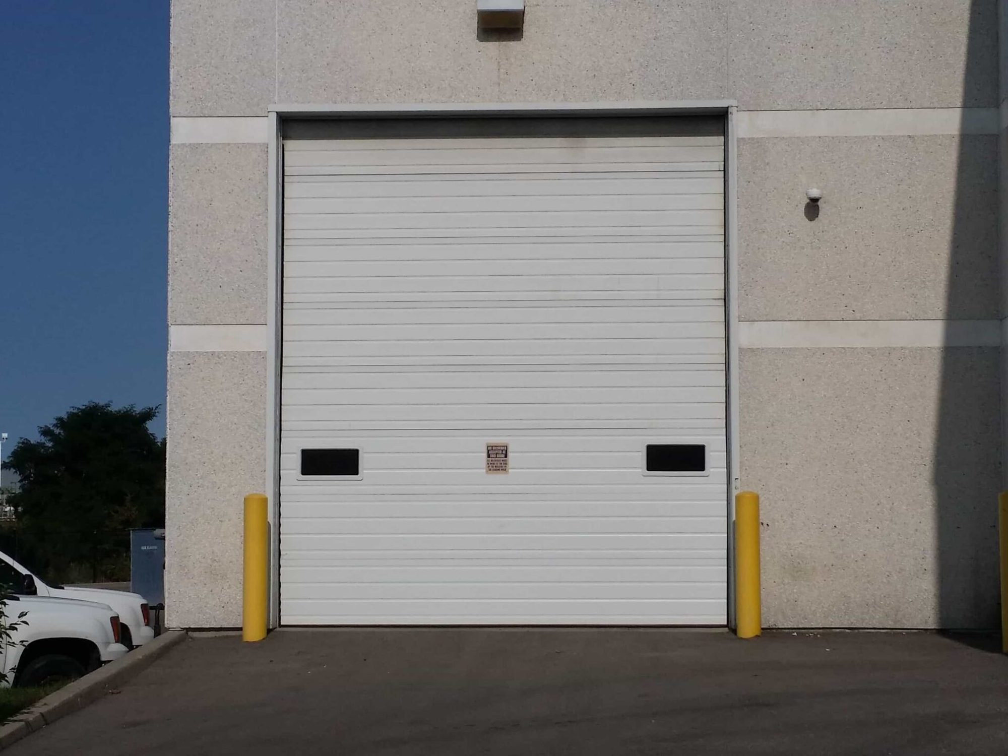 A commercial sectional overhead door built from hinged horizontal panels running in a vertical track