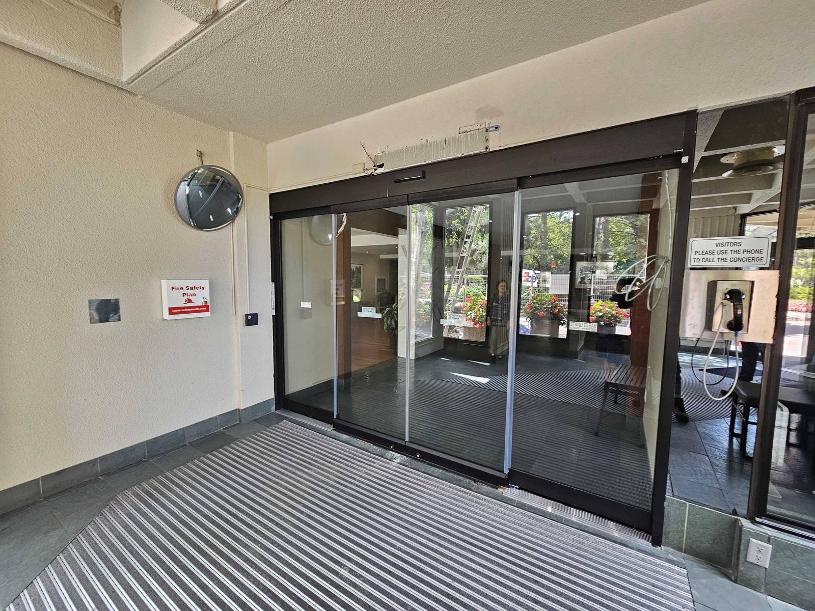 Bi-parting automatic sliding glass entrance doors in dark bronze aluminum framing at the MTCC 650 Atrium II building in Toronto, installed by Canuck Door Systems
