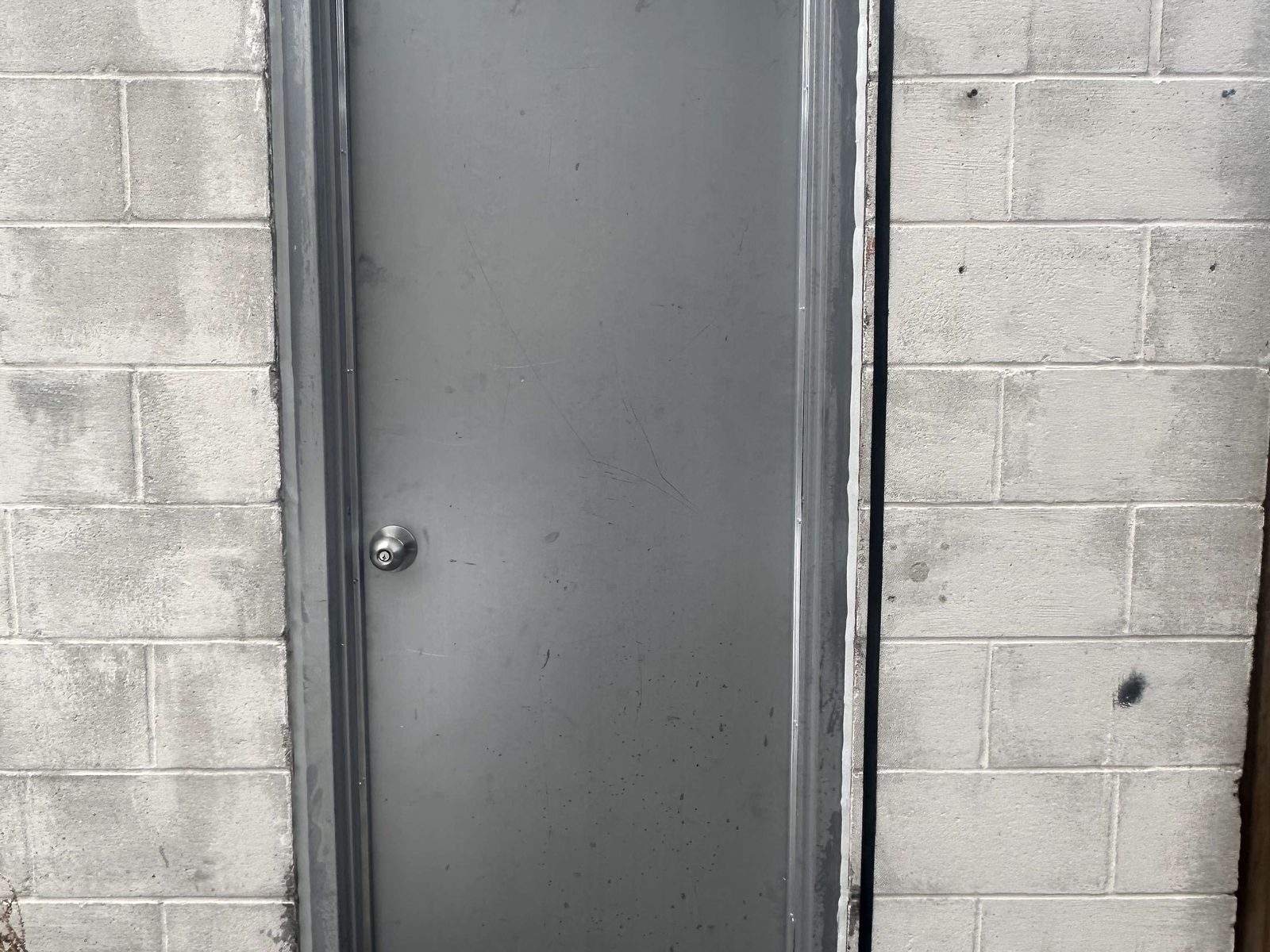 A hollow metal door hung in a welded steel frame set into a block wall, installed by Canuck Door Systems