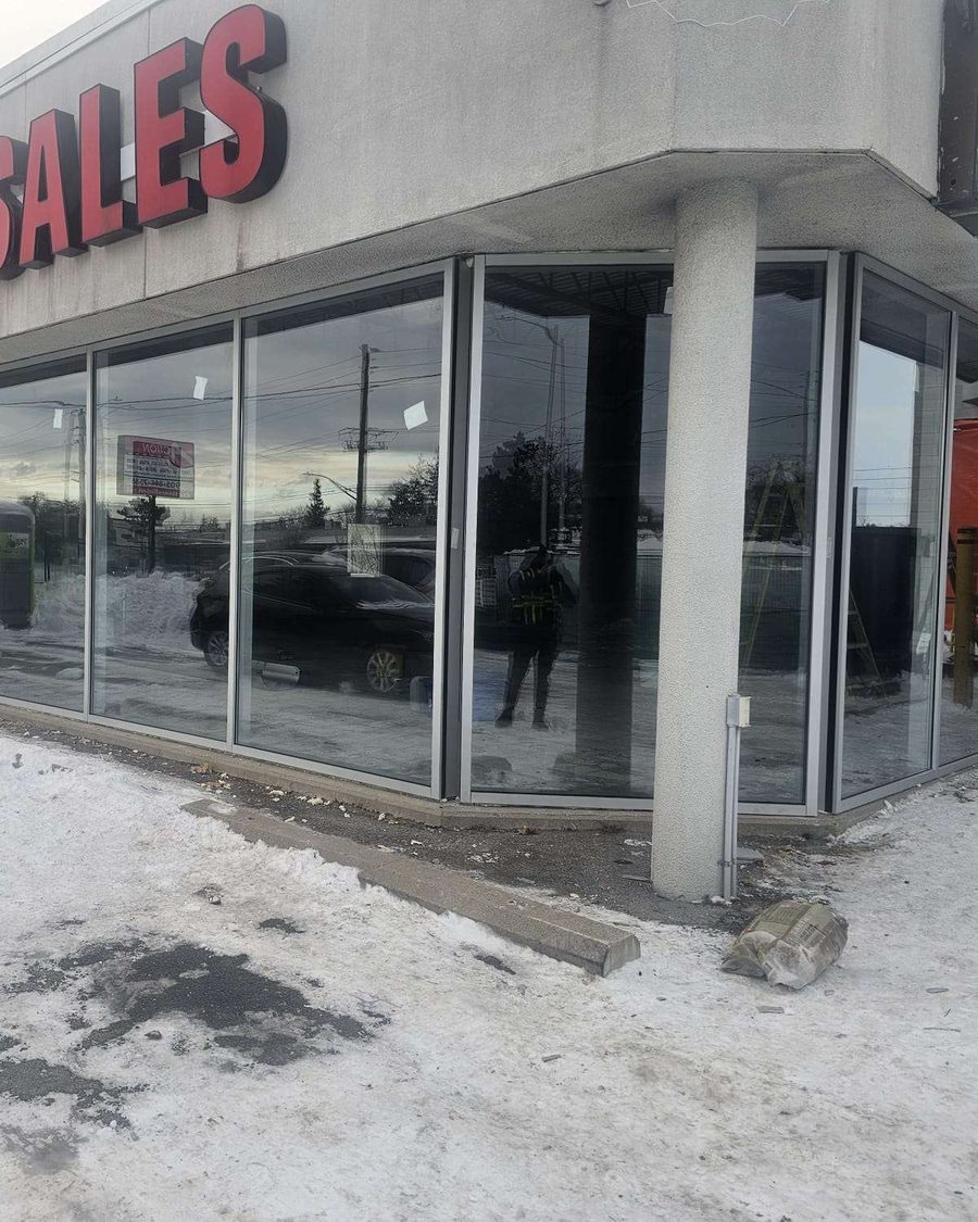 Aluminum-framed storefront glazing wrapping the corner of a single-storey commercial building, installed by Canuck Door Systems