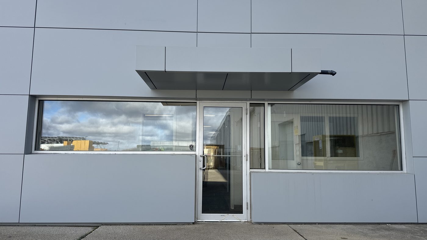 Glazed aluminum window band and entrance on a commercial elevation at 30 Todd Road in Georgetown, replaced by Canuck Door Systems