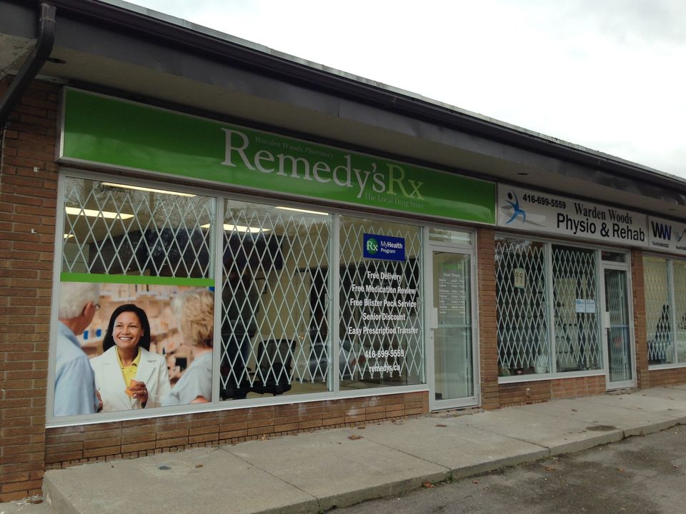 White expandable security gates fitted behind the windows of a pharmacy storefront