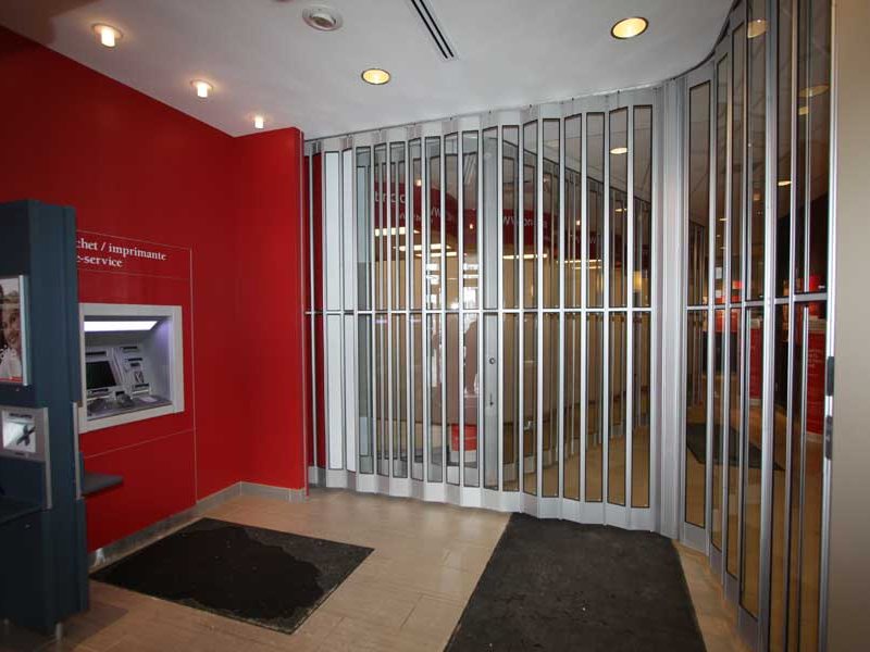 Side-folding closure with clear panels shutting off a bank lobby and ATM area