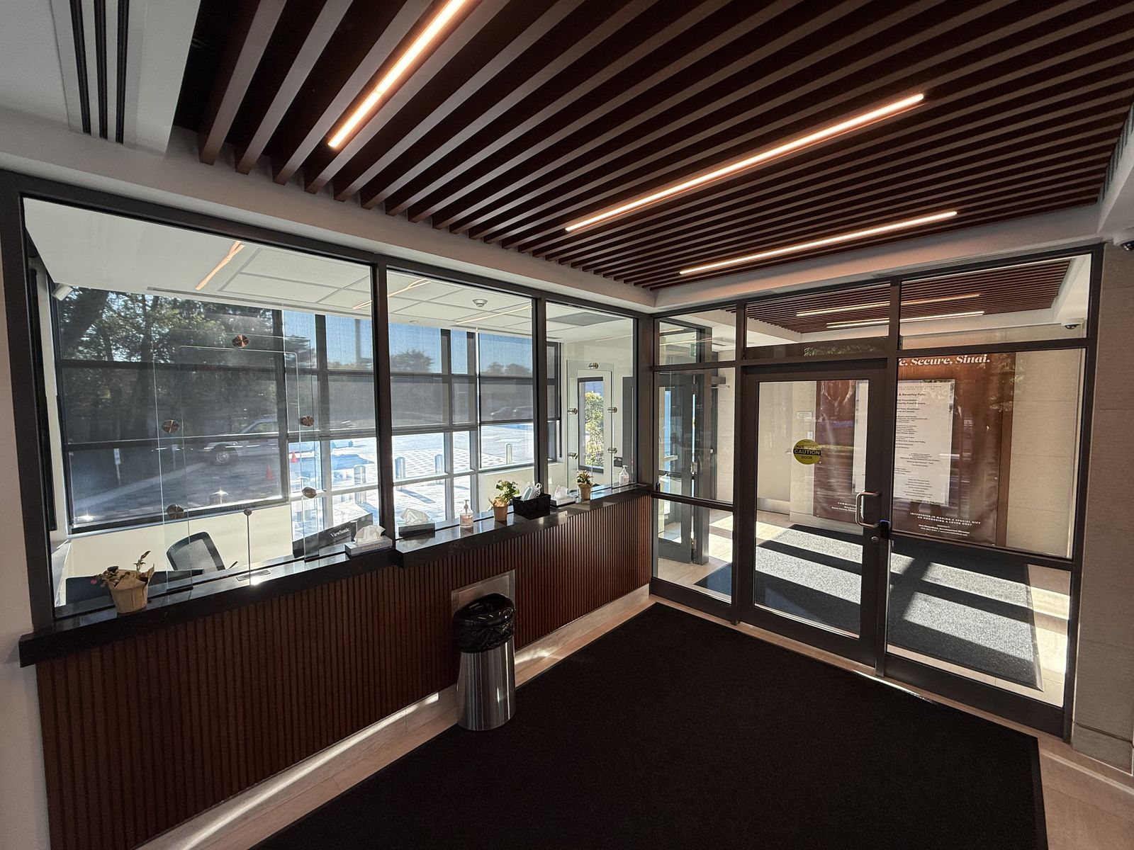 Commercial glass-and-aluminum entrance doors and matching glazed vestibule in a Toronto building lobby, supplied and installed by Canuck Door Systems
