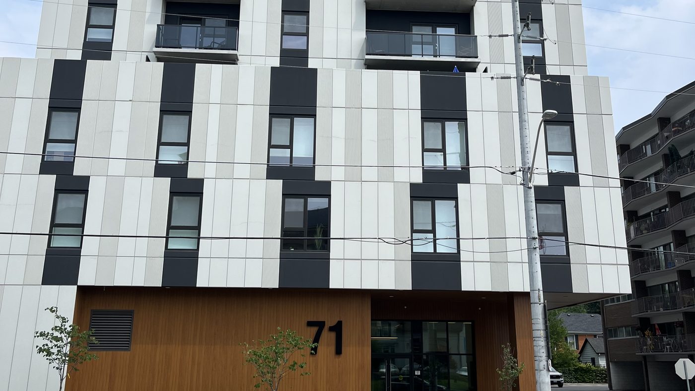 Centurion's mid-rise building in Dundas, with a banded dark-and-light facade above a wood-clad ground-floor entrance