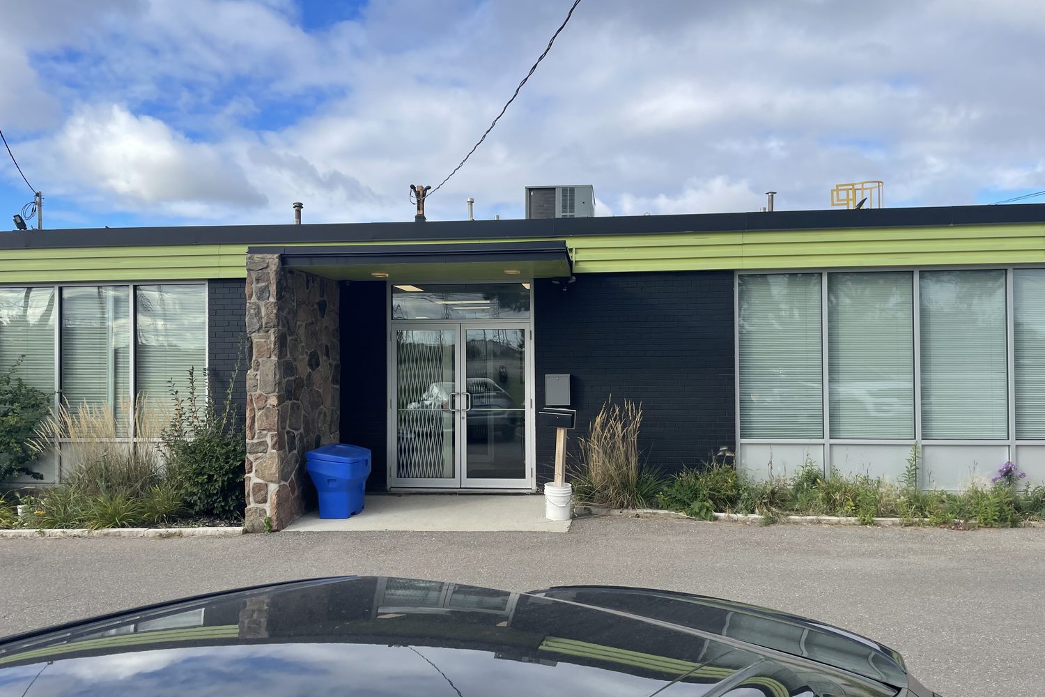 A glazed aluminum storefront entrance and window on one of the commercial units at Kelfield Street in Etobicoke, set into dark cladding