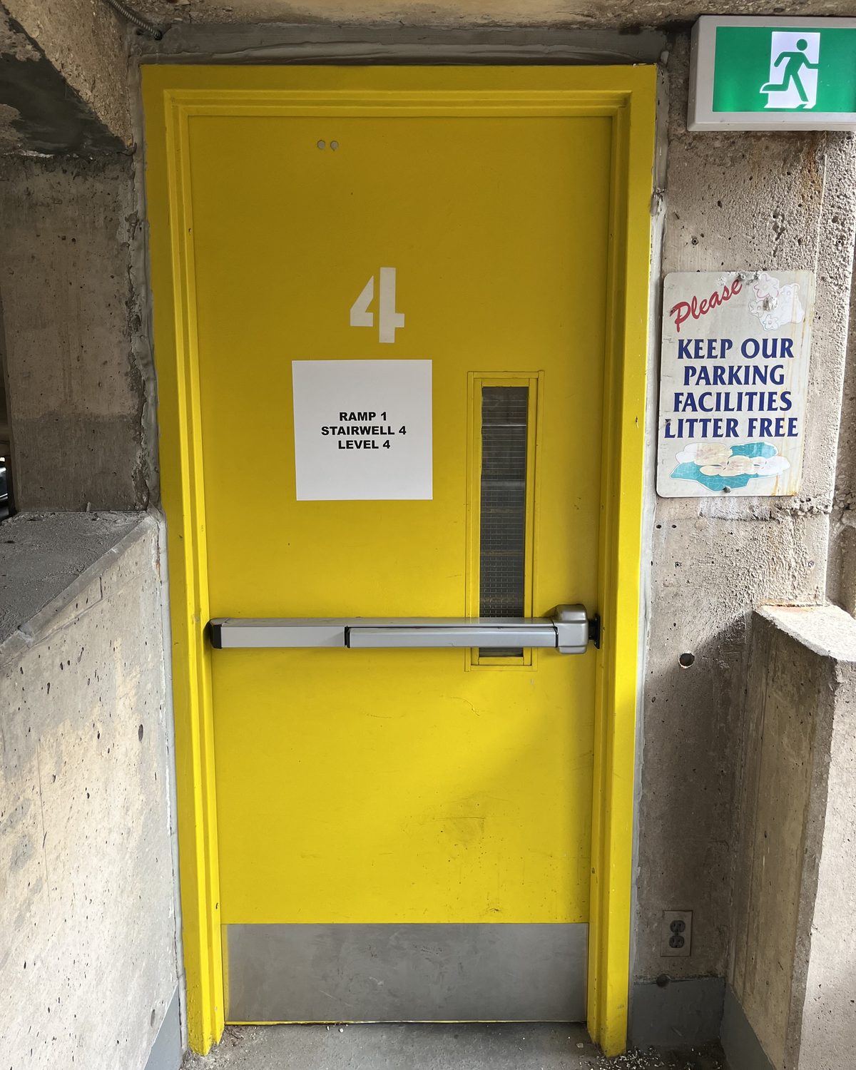 A yellow hollow metal stairwell door with a panic bar and a large number 4, in the St. Joseph's Healthcare Hamilton parking garage