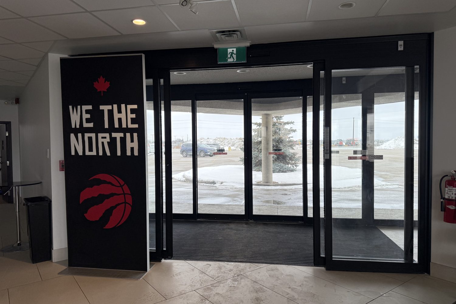 The inside of the new automatic sliding door entrance at Signature Aviation in Mississauga, with dark aluminum framing and a tiled floor