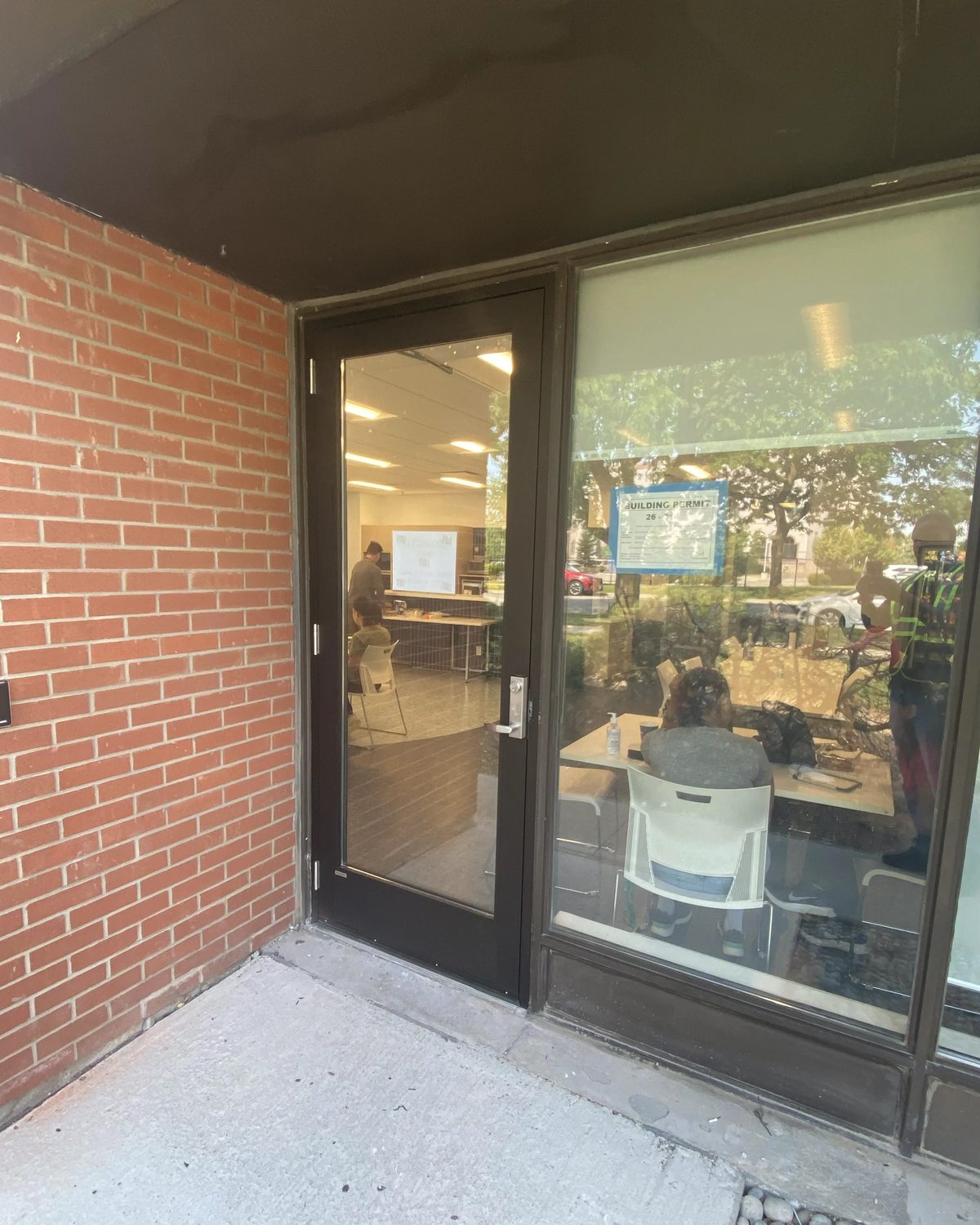 The replacement Herd Aluminum 1451 series storefront door and frame in the same Mississauga masonry opening, with a clean sill and new lever hardware, installed by Canuck Door Systems
