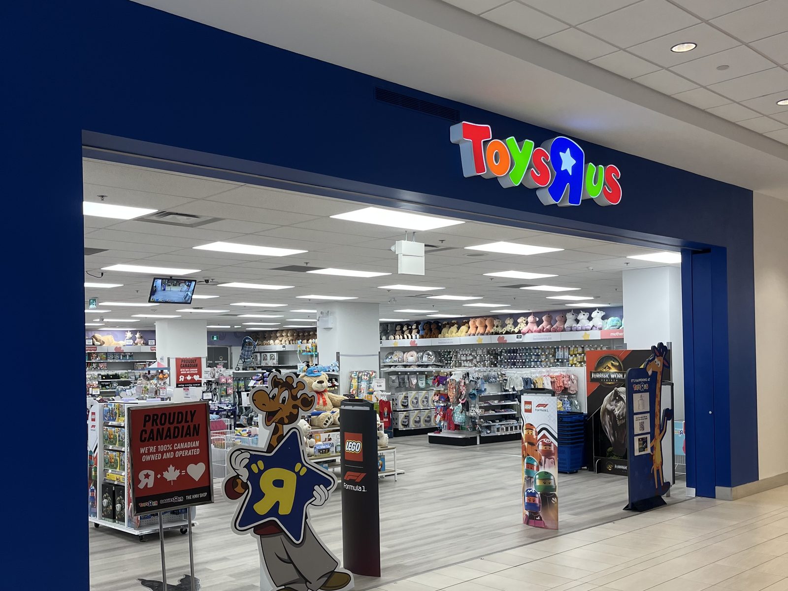 The entrance of a new Toys "R" Us store in North York, a wide opening in a blue wall under the store's sign, with the shop floor beyond