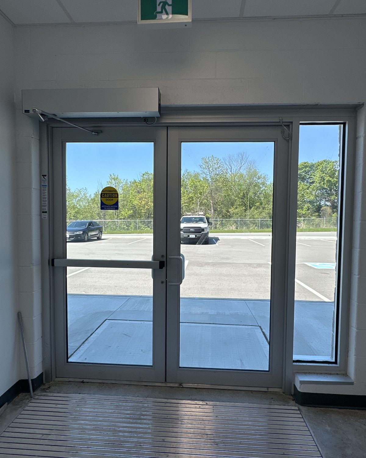An interior aluminum entrance frame with glass doors and sidelites inside the MTO patrol yard building, looking out to the parking area