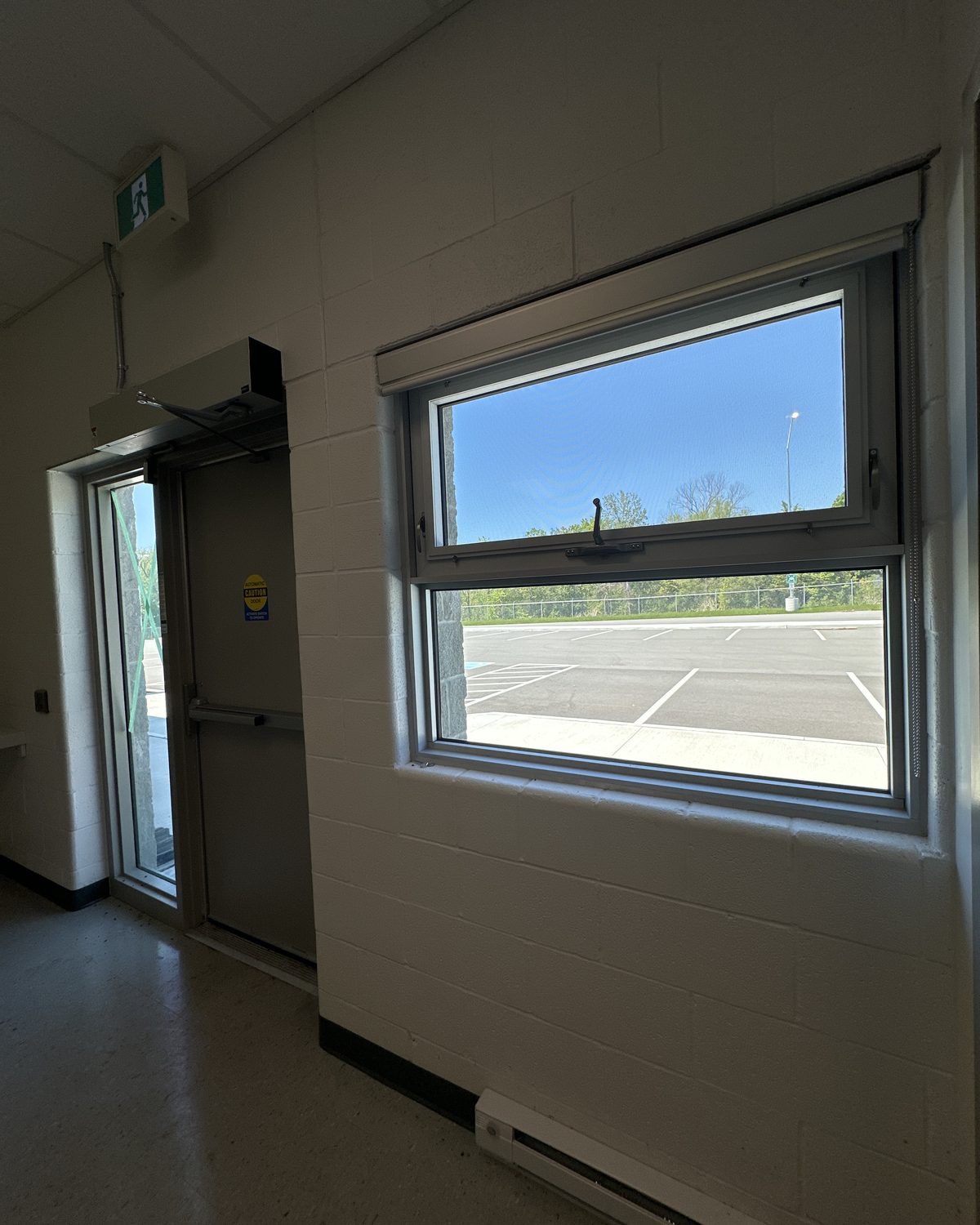 An aluminum window with an opening vent seen from inside a room at the MTO patrol yard building