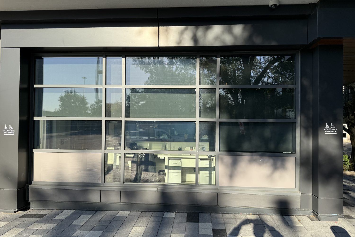 A grey aluminum curtain wall with large glass panels on the exterior of Temple Sinai Congregation in Toronto