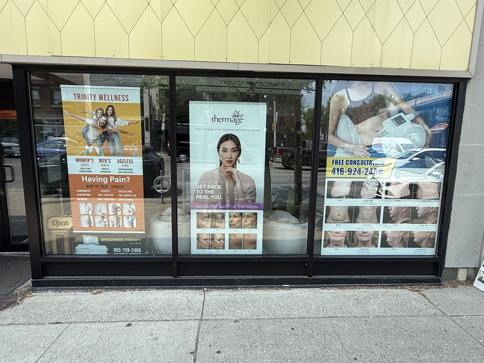 A new glass and aluminum storefront in dark framing along the sidewalk at 3434 Yonge Street in Toronto, with large display windows and an entrance door, installed by Canuck Door Systems