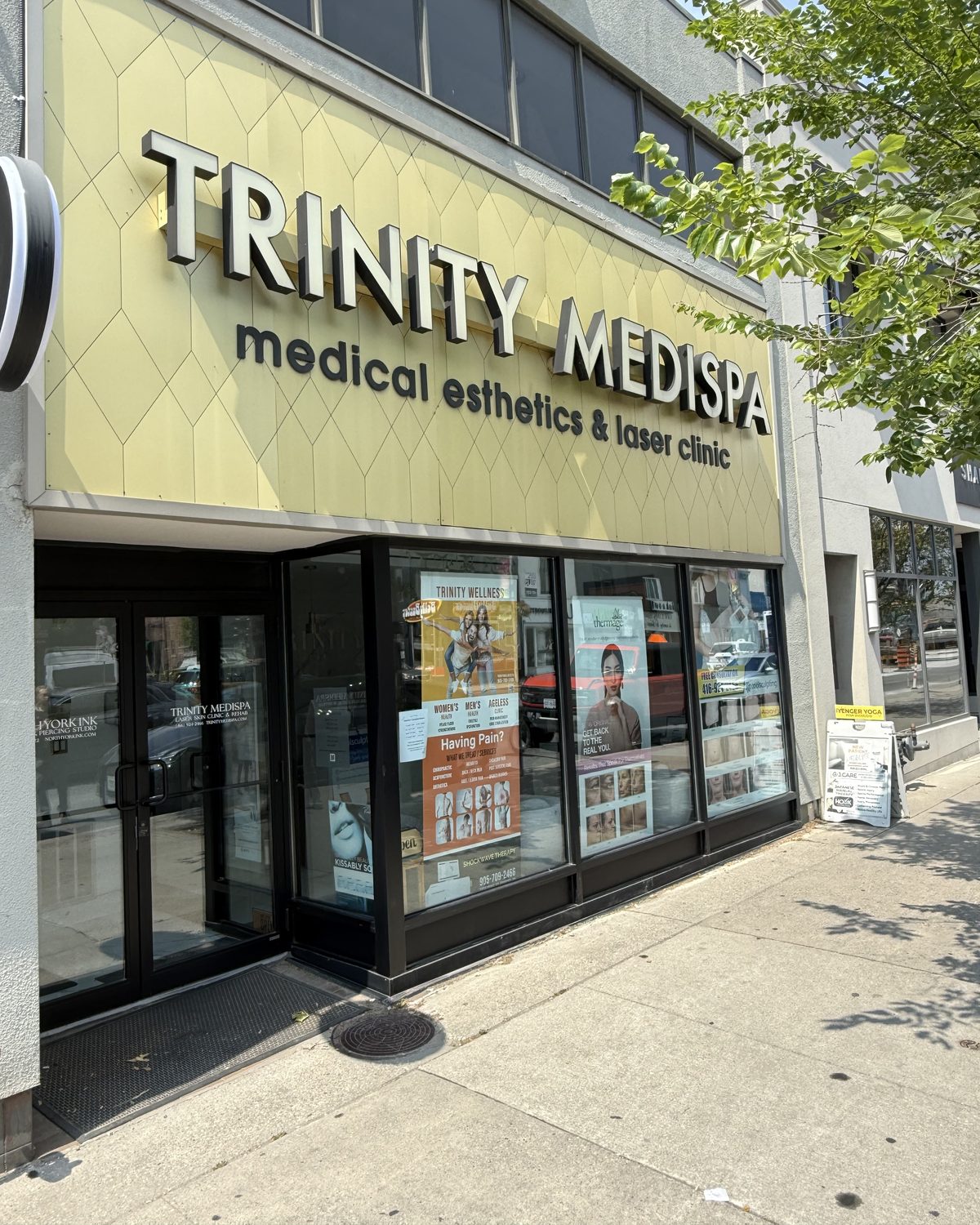 The new glass and aluminum storefront at 3434 Yonge Street in Toronto seen at an angle along the sidewalk, with its display windows and entrance