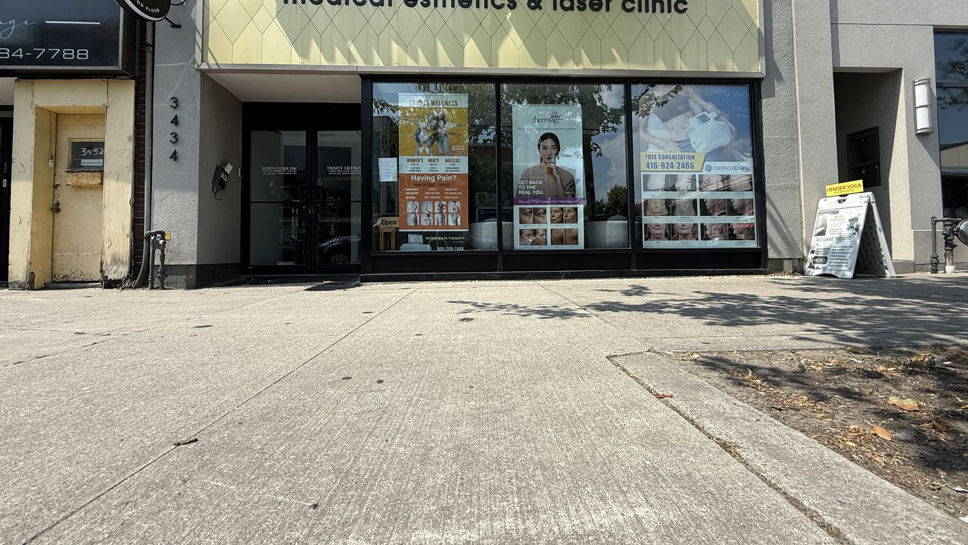 The storefront at 3434 Yonge Street in Toronto seen from across the sidewalk, between neighbouring shops on the street