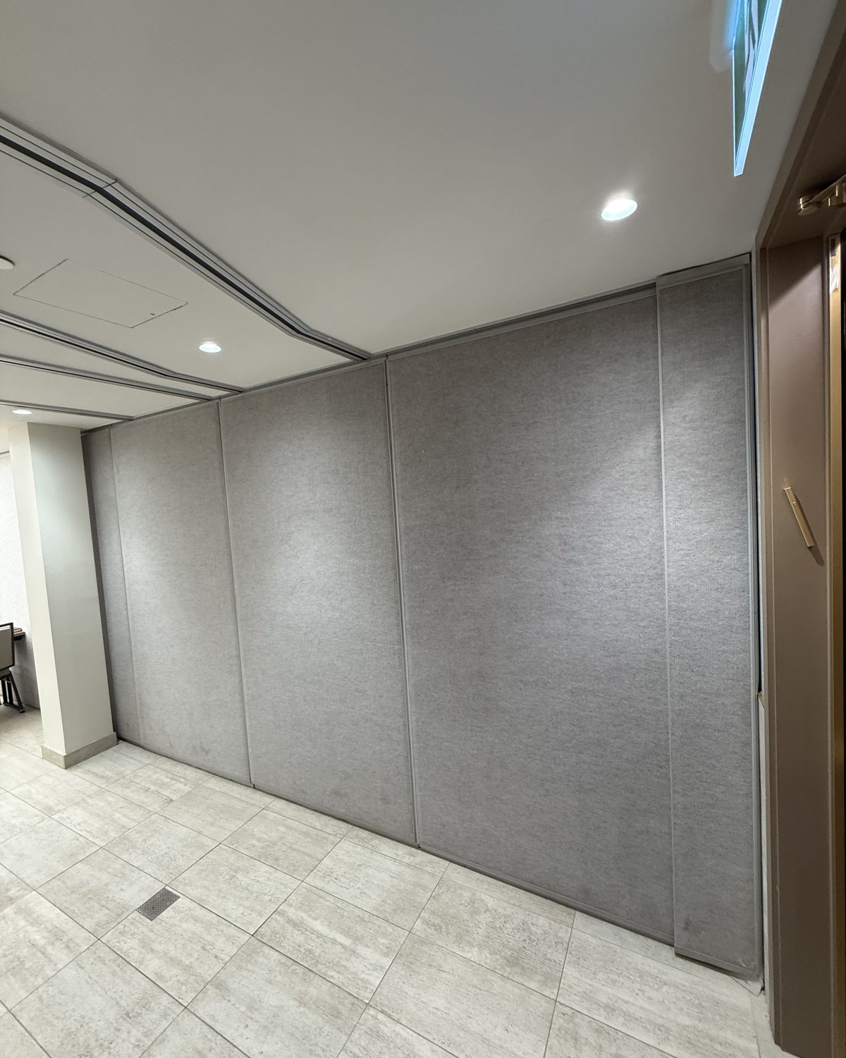 A closed operable wall of grey carpeted panels running floor to ceiling across a room at the Eitz Chaim & Kollel School in Vaughan