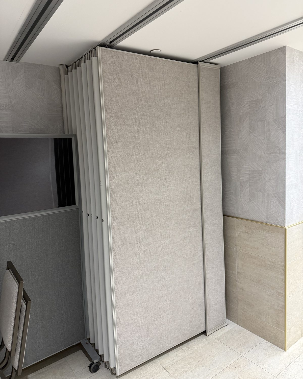 Operable wall panels folded back and stacked against the side wall of a school room in Vaughan, seen along the ceiling track