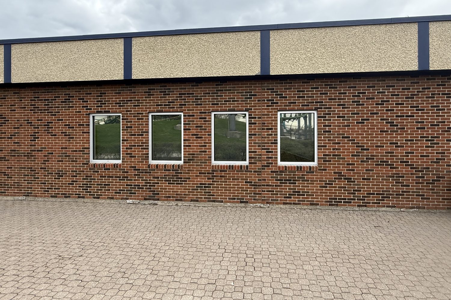 A row of new aluminum windows evenly spaced along the brick wall of a single-storey building at Canada's Wonderland