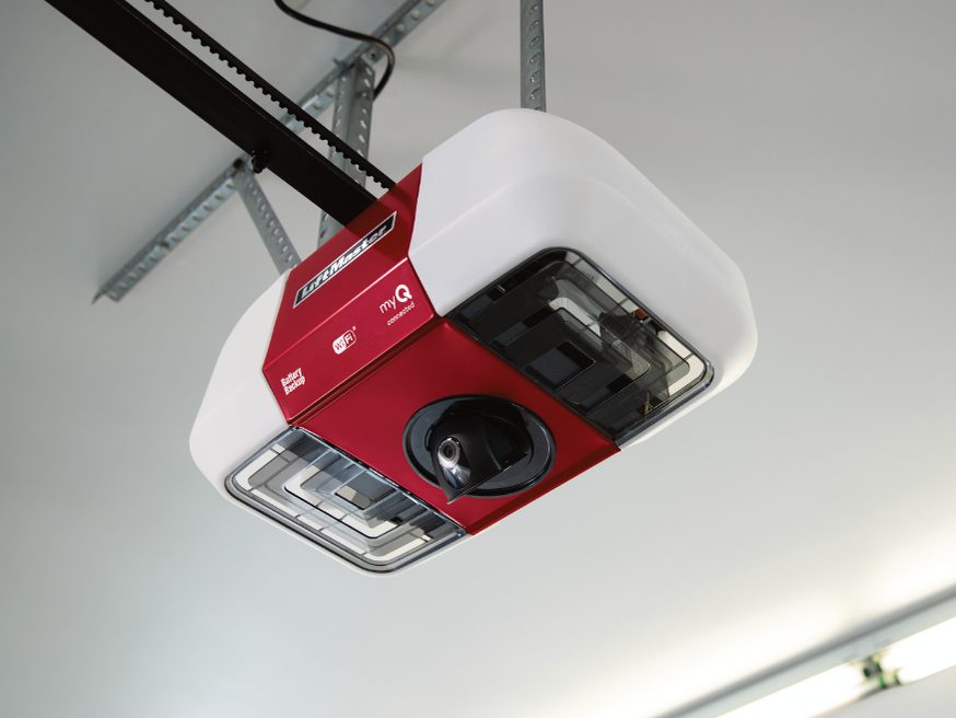 A LiftMaster myQ garage door opener head mounted on a garage ceiling, with an integrated camera and the belt rail running away from it